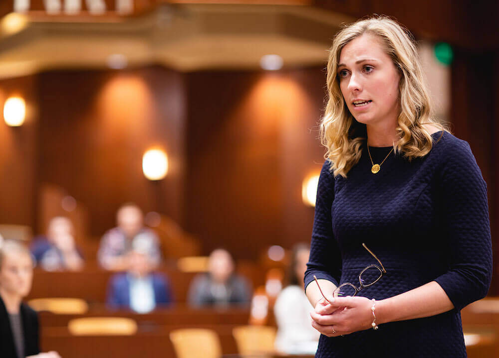 A law student holds her eyeglasses and pleads her case to the mock jury during a mock trial in the ceremonial courtroom