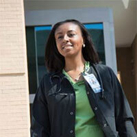 A nursing student walks out of a hospital after her shift