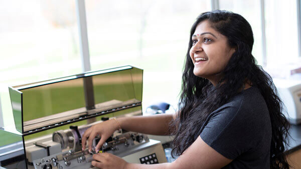 An undergraduate student works with equipment in a lab