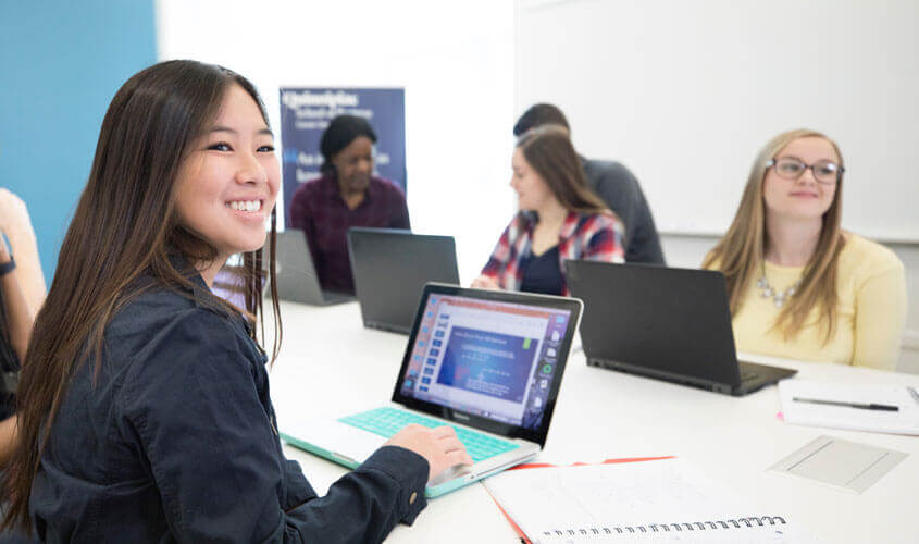 Students with computers in an undergraduate business class.