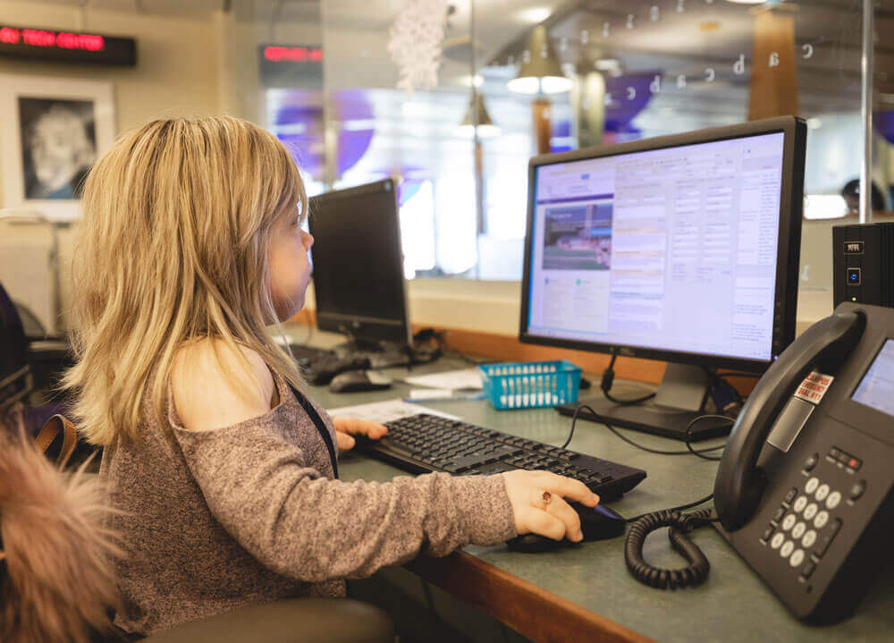 A graduate student works on campus in the technology center