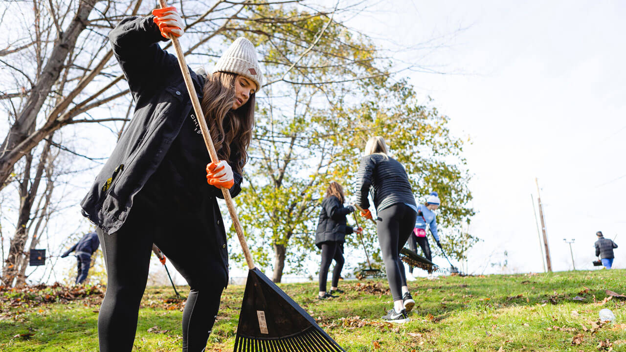 Nicole Kaczmarski, Law in Society ’22 from the Chi Omega Sorority, as well as other Quinnipiac students, holding a rake to remove leaves at North Haven Animal Shelter as part of Greek Day of Service.