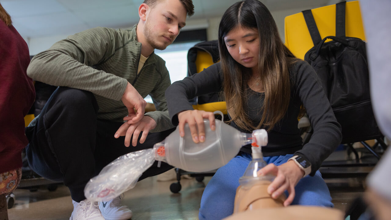 Students perform hands-on CPR training.