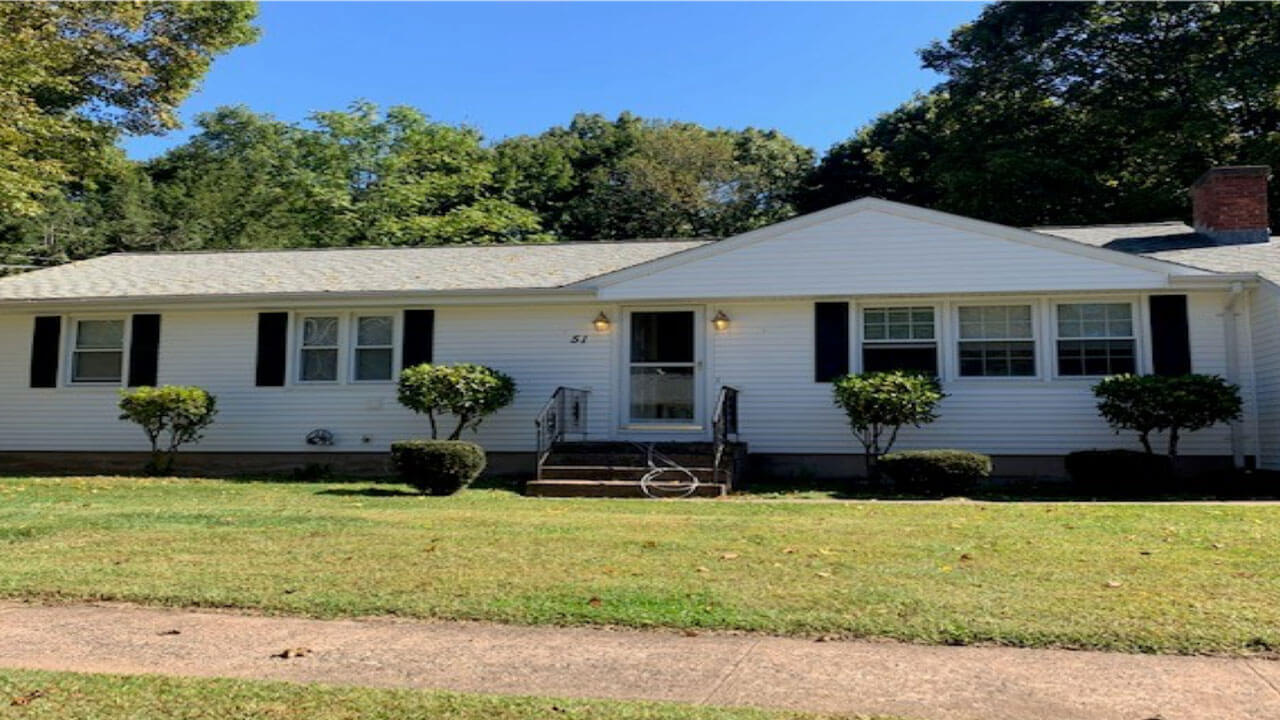 White ranch house with shrubbery on 60 Lucien Drive