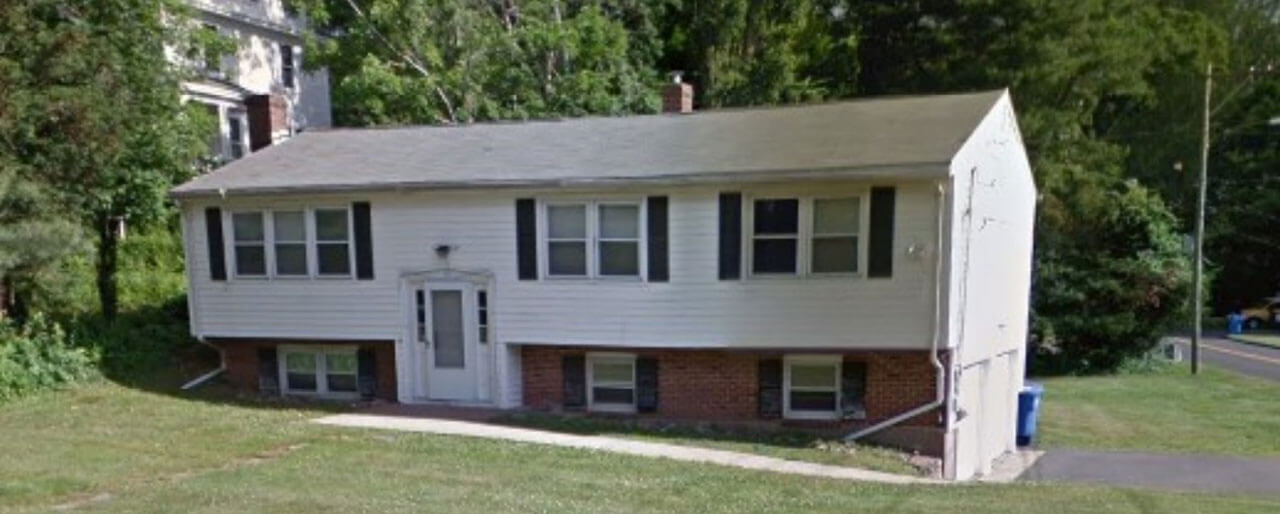 Brick and white house facing sideways from road on 62 Ives Street