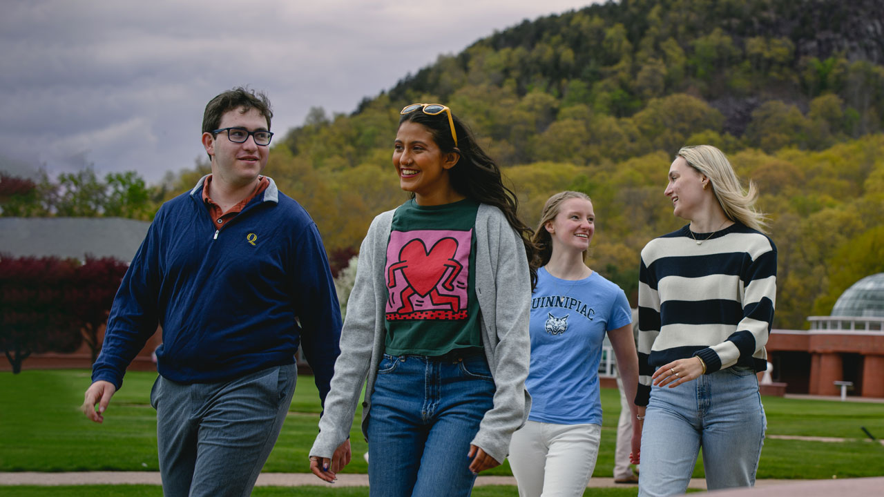 Students walk between the Arnold Bernhard Library and the quad on our Mount Carmel Campus