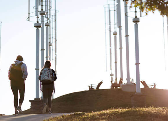 Students walk near wind turbines