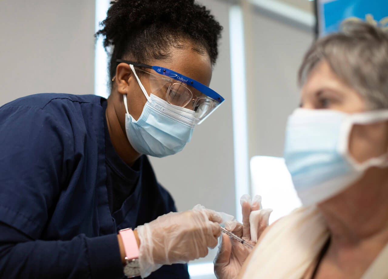 A Quinnipiac student administers a covid vaccine to a patient