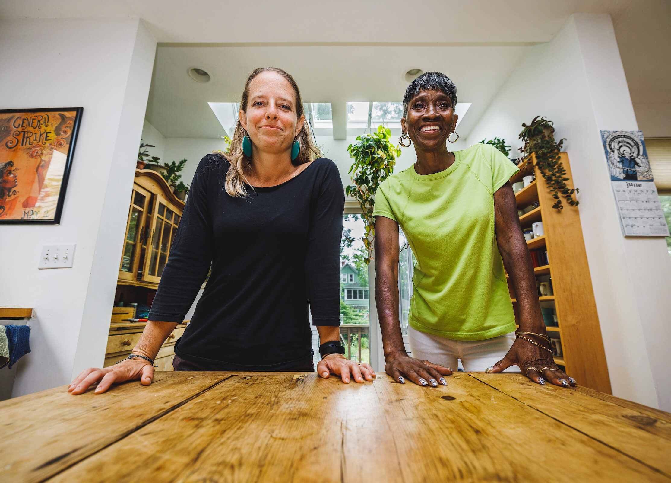 Amber Kelly and Janice Murray stand leaned over a table smiling