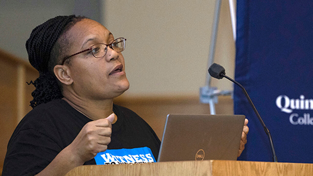 Sabrina Butler-Smith speaks from a podium in the Mount Carmel Auditorium