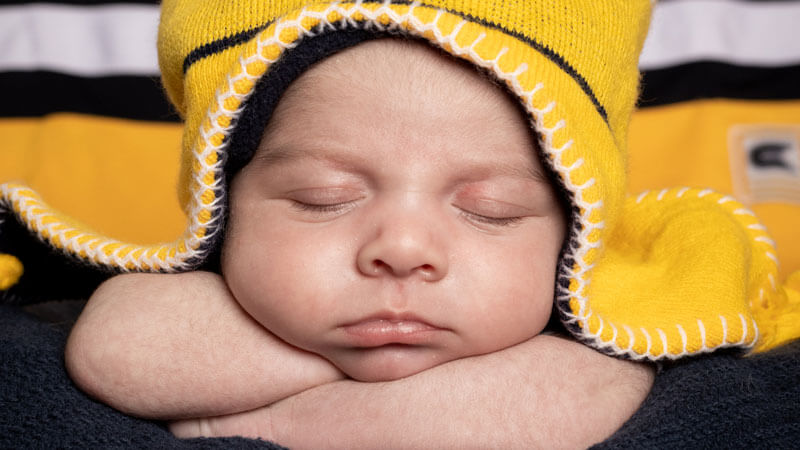 Baby with a blanket covering the top of his head